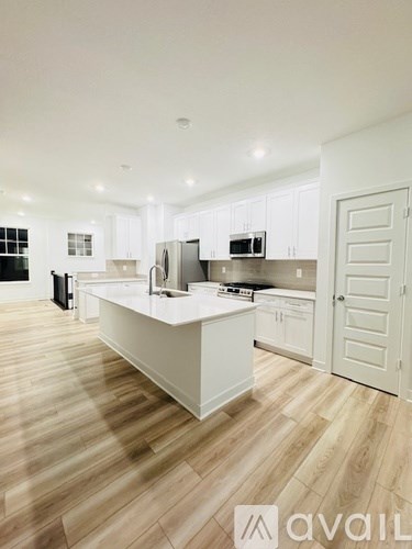A kitchen with white cabinets and a white island.