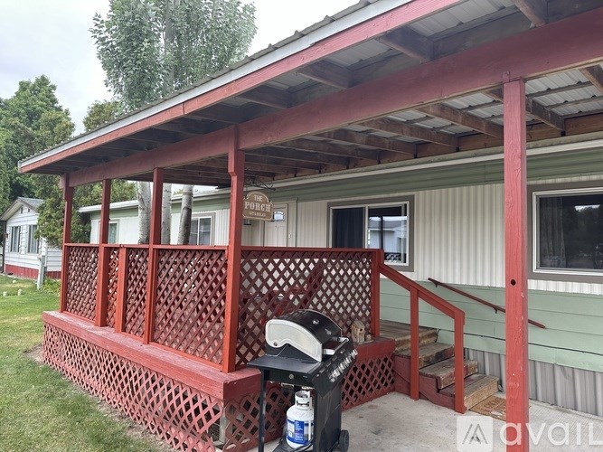 A red and white porch with a red railing and a white door.