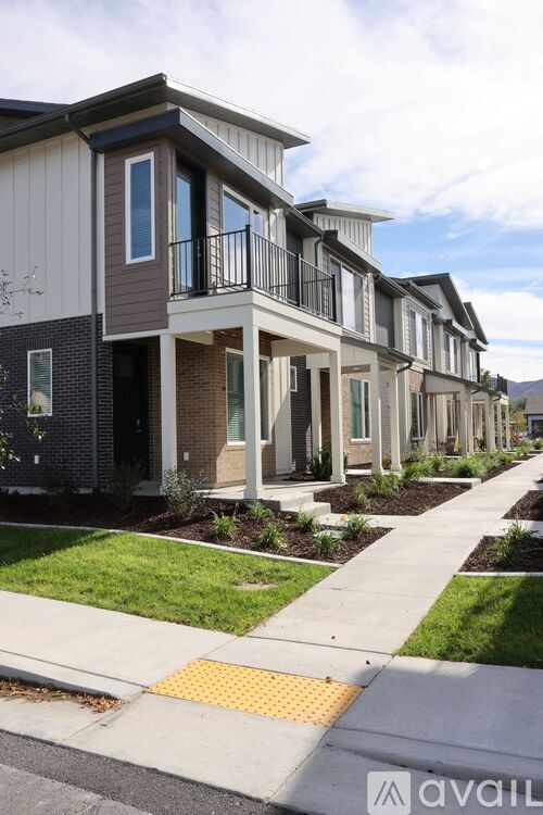 A row of houses with a sidewalk in front.