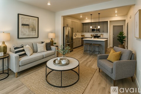 A modern living room with a grey sofa, a coffee table, and a kitchen in the background.