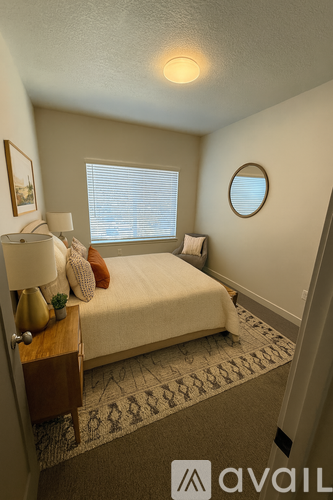 A bedroom with a bed, nightstand, and window.