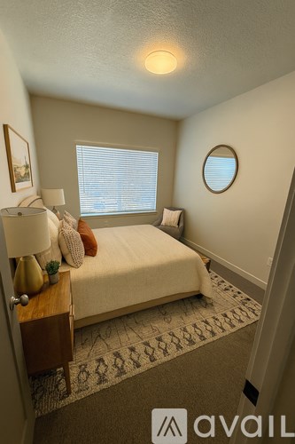 A bedroom with a bed, nightstand, and window.