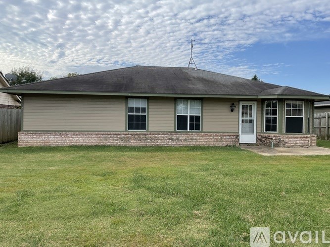 A house with a grey roof and a white door is available for rent.