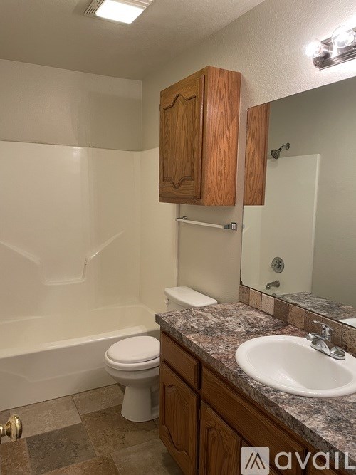 A bathroom with a toilet, sink, and mirror.