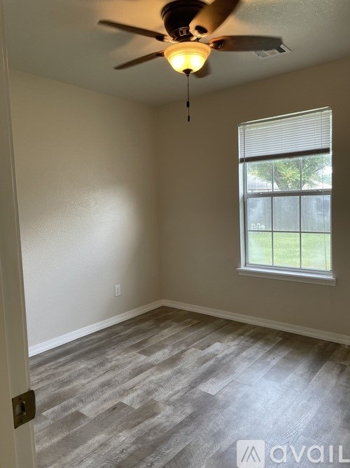 A room with a ceiling fan and a window.