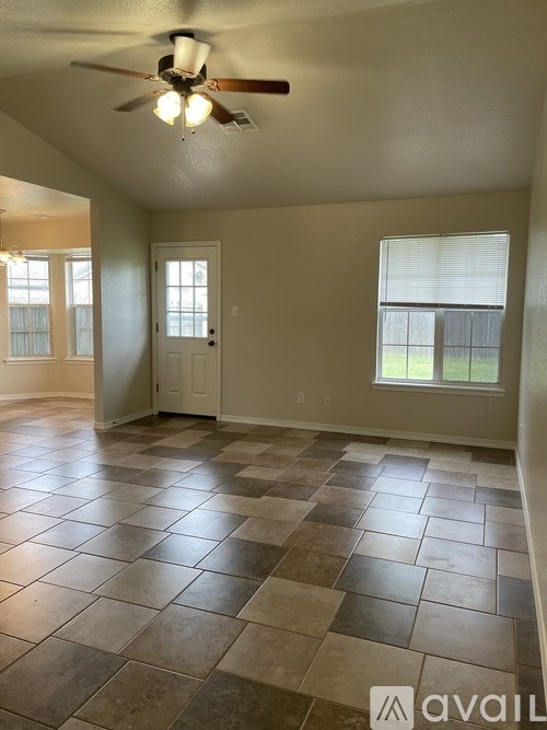 A room with tile flooring and a ceiling fan.