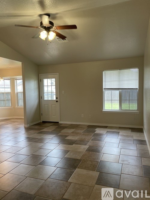 A room with a ceiling fan and tile flooring.