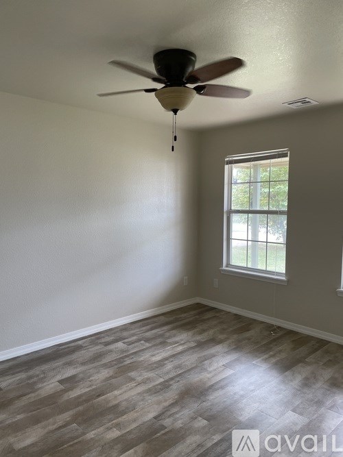 A room with a ceiling fan and a window.