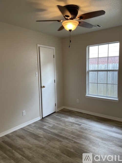 A room with a ceiling fan and a window.