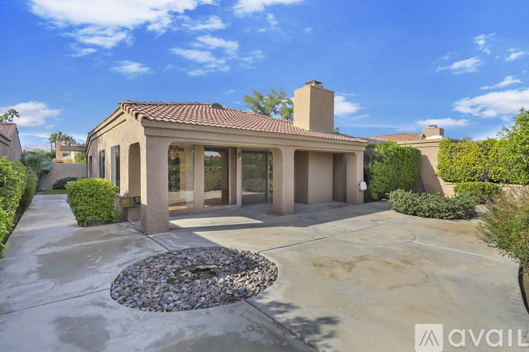 A house with a stone patio in front.