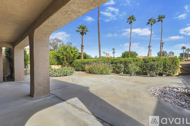 A patio area with a cement floor and a stone border.
