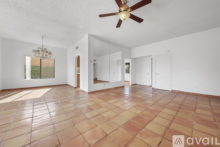 A spacious room with a ceiling fan and tiled flooring.