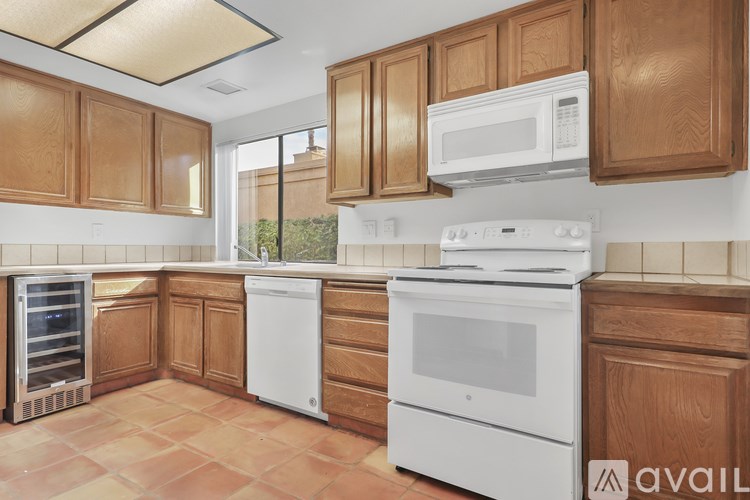 A kitchen with wooden cabinets and white appliances.
