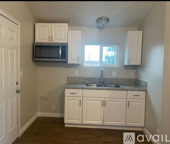 A kitchen with white cabinets and a granite countertop.