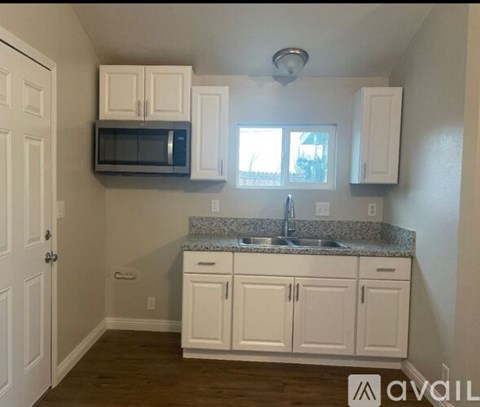 A kitchen with white cabinets and a granite countertop.