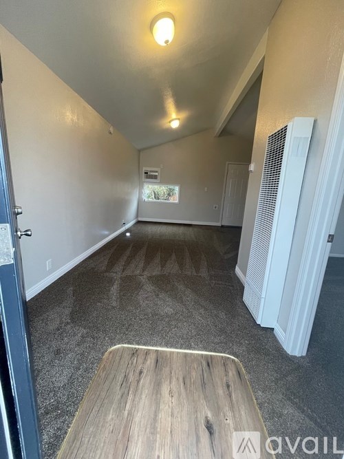 A long, narrow hallway with a wooden table on the left and a white radiator on the right.