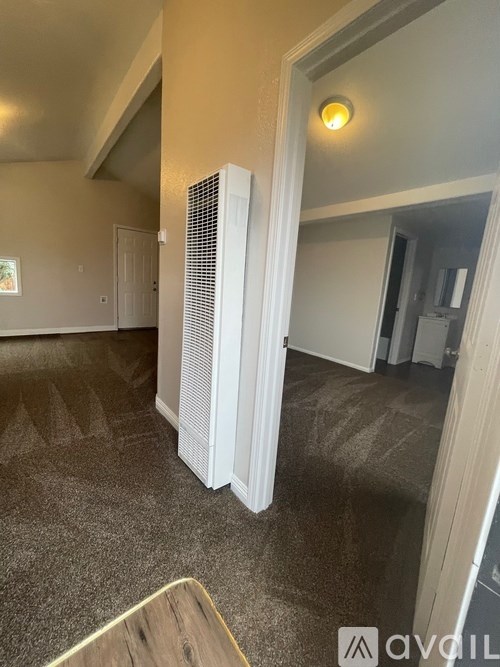 A room with a carpeted floor and a white radiator.