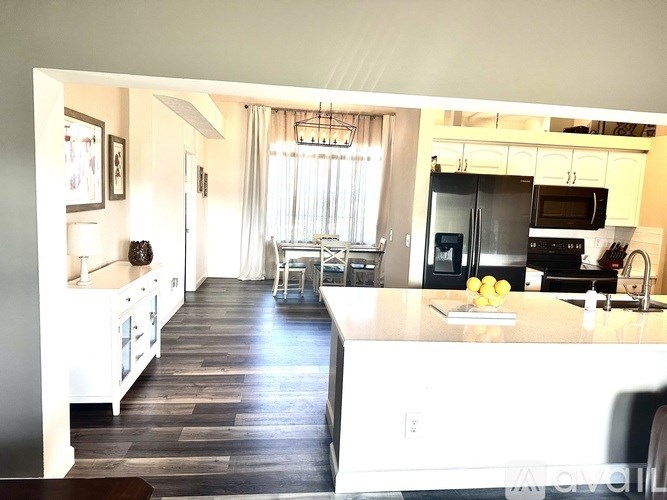 A kitchen with a white counter and a wooden floor.