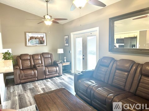 A living room with a brown leather couch and a wooden coffee table.