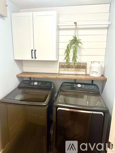 Two front loading washing machines in a small laundry room.