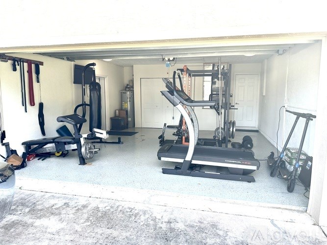 A garage with a treadmill, weights, and exercise equipment.