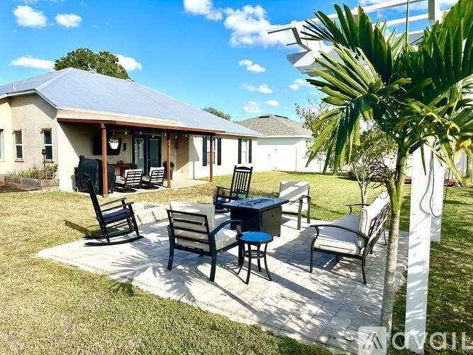 A patio with a table and chairs is surrounded by a white fence.