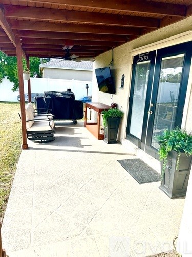 A patio with a table and chairs under a roof.