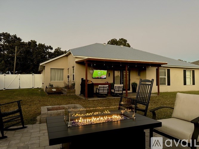 A house with a patio and a fire pit in the foreground.