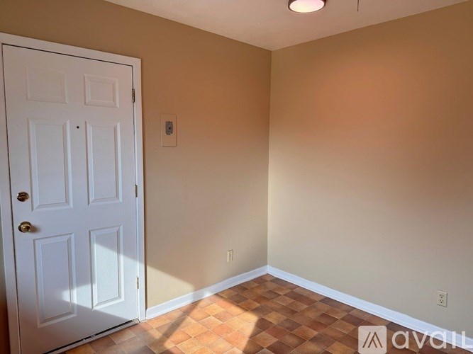 A room with a white door and a tiled floor.