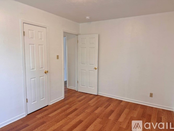 A room with two doors and wooden flooring.