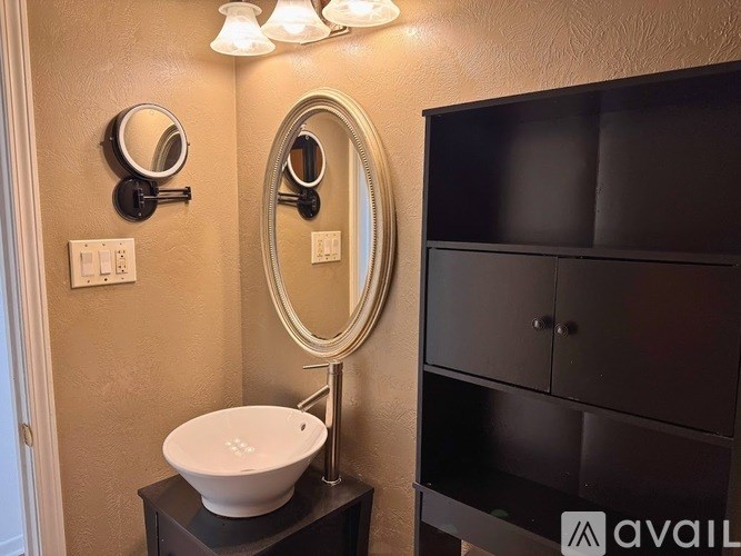 A bathroom with a sink, mirror, and cabinet.
