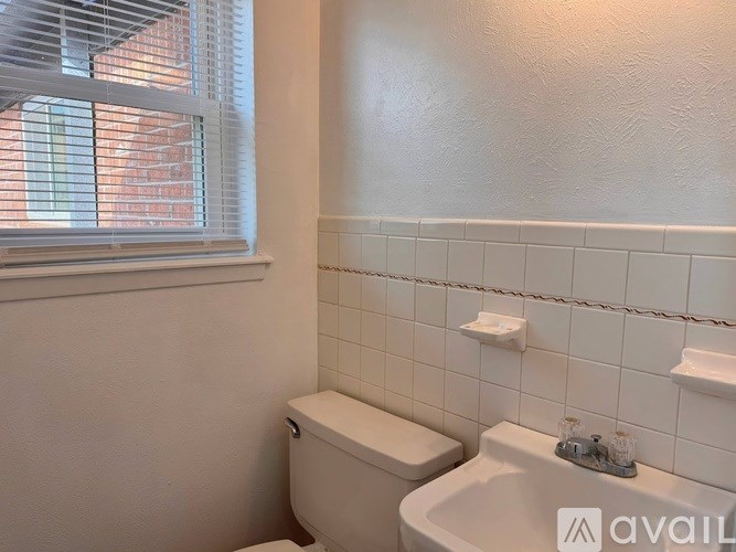 A white toilet sits next to a sink in a bathroom.