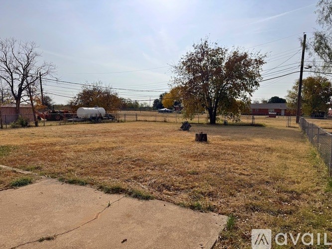 A field with a tree and a truck in the background.