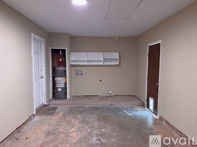 A room with a white door, a white air conditioner, and a white wall.