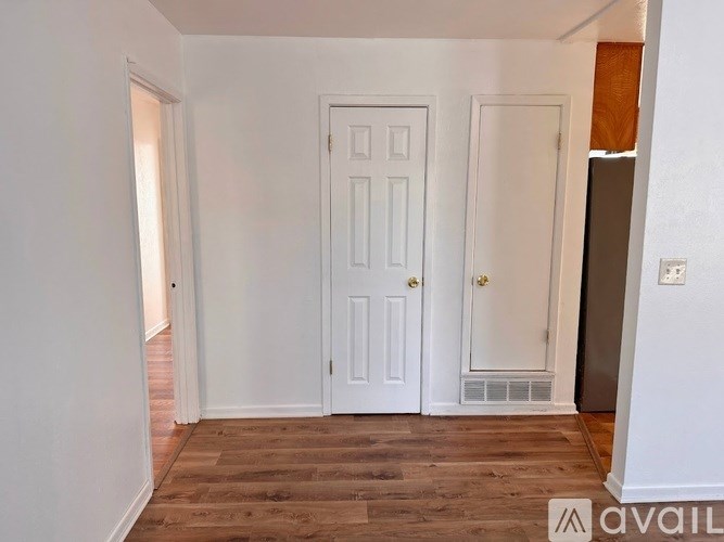 A room with a white door and a window with blinds.