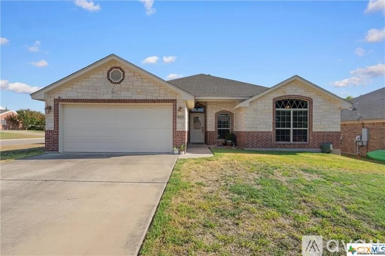 A two-story house with a garage door and a window.