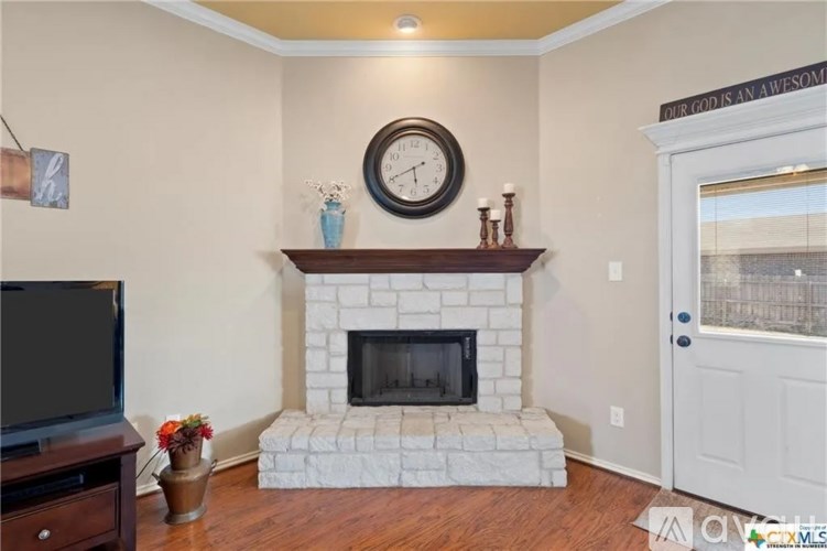 A living room with a fireplace and a clock on the wall.
