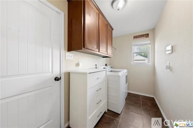 A small, clean kitchen with white appliances and brown cabinets.