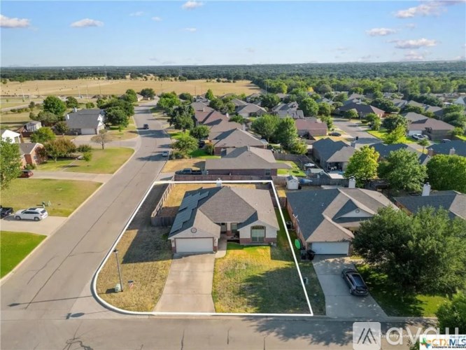 A bird's eye view of a residential area with houses and cars.