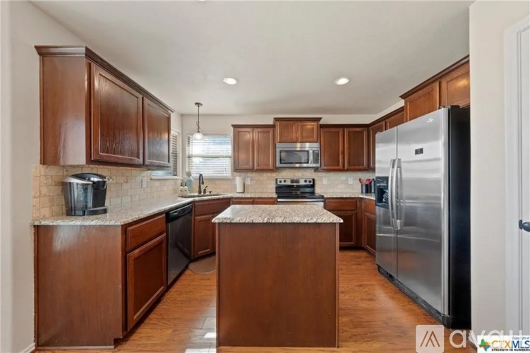 A kitchen with wooden cabinets and a granite countertop.