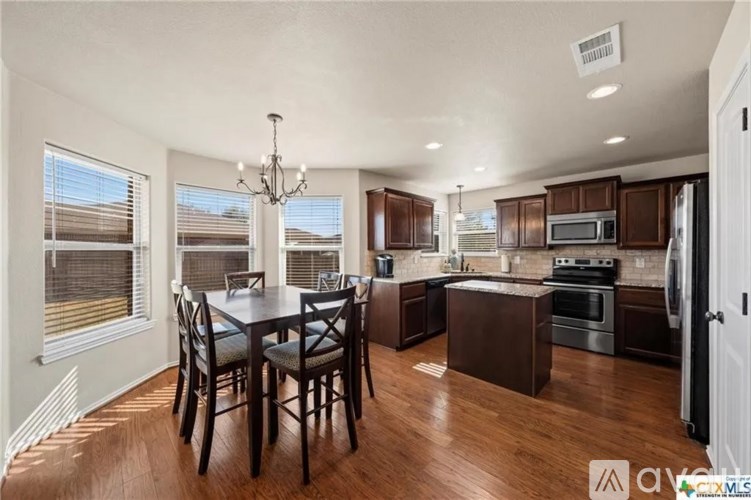 A well-lit kitchen and dining area with wooden floors and modern appliances.