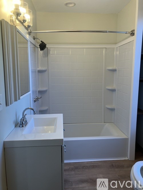 A white bathroom with a sink, toilet, and bathtub.