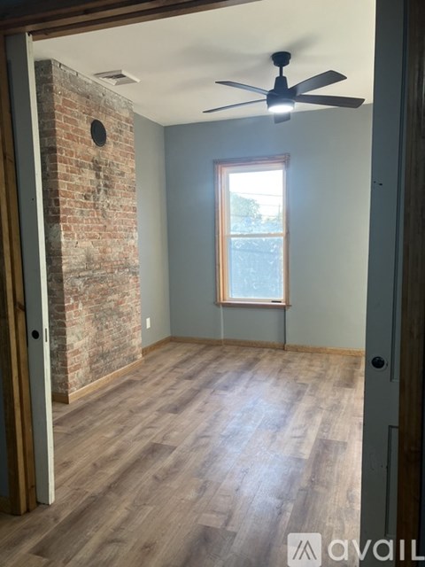 A room with a brick wall and wooden flooring.