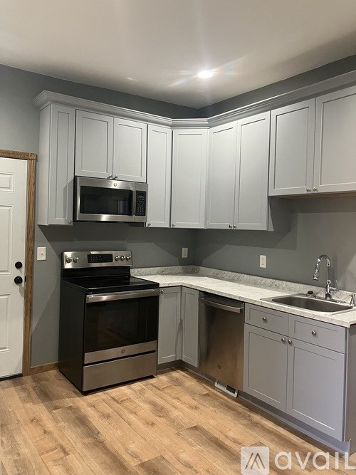 A kitchen with a black oven and microwave, and a sink with a faucet.