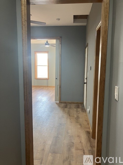 A hallway with wooden floors and a light on the ceiling.