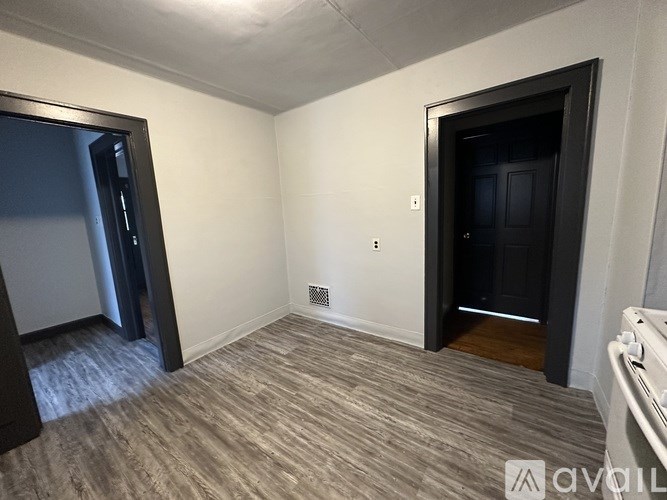 A room with a black door and a grey carpet.