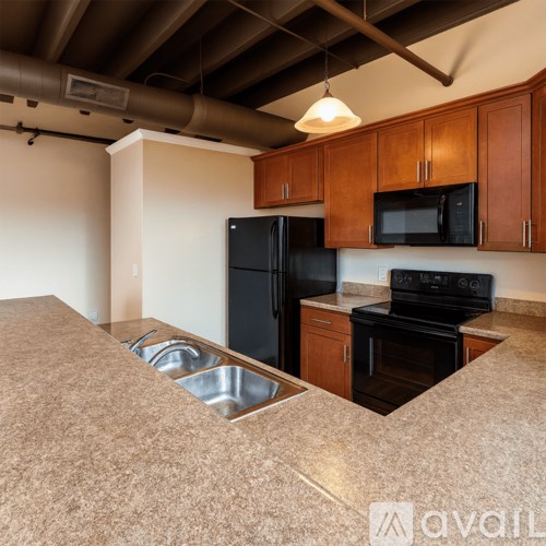 A kitchen with black appliances and wooden cabinets.