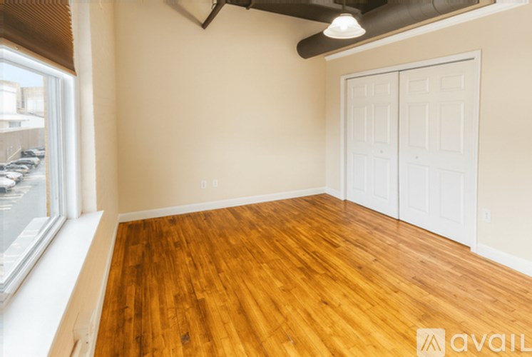 A room with wooden flooring and a white door.
