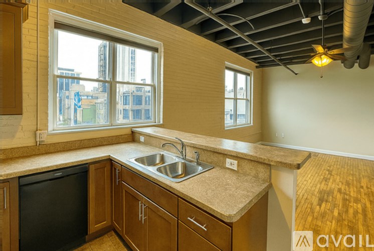 A kitchen with wooden cabinets and a window overlooking a cityscape.