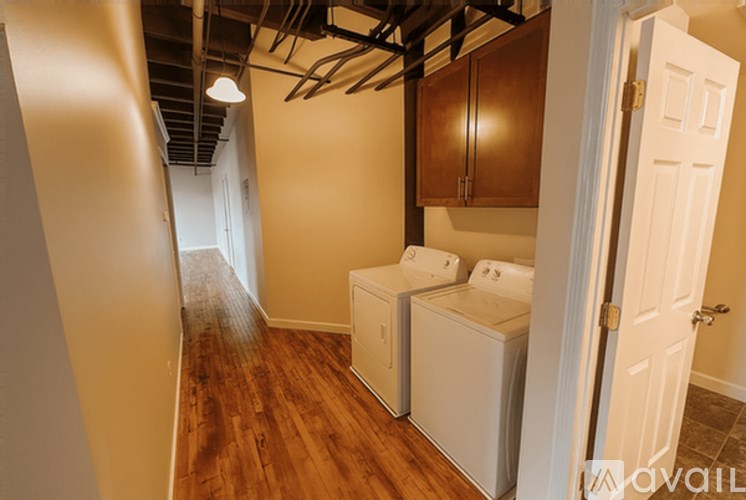 A bathroom with a toilet, sink, and wooden floors.